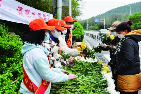 志愿者在路边送花